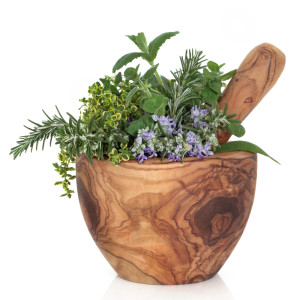 aromatiche in fiore dentro a mortaio in legno